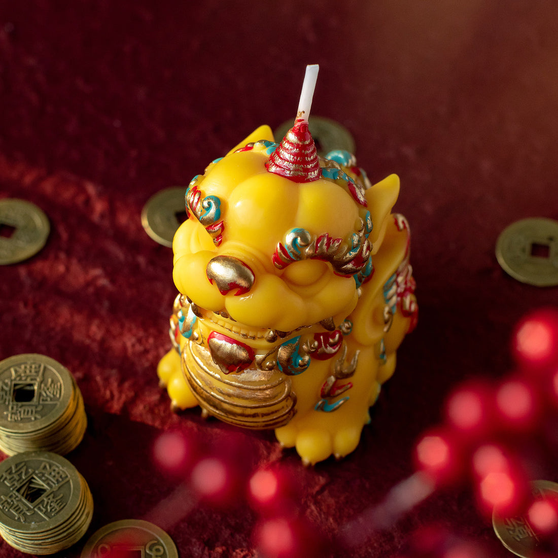 Top view of a Pixiu fortune candle by Southlake Gifts surrounded by Chinese coins, a symbolic handmade soy wax candle designed as a meaningful Lunar New Year gift and decorative keepsake.