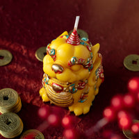 Top view of a Pixiu fortune candle by Southlake Gifts surrounded by Chinese coins, a symbolic handmade soy wax candle designed as a meaningful Lunar New Year gift and decorative keepsake.
