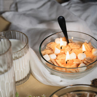 Handcrafted Cinnamon Toast Crunch Candle lit with soft flames beside a glass of milk, featuring wax cereal squares and marshmallows — a charming realistic décor candle perfect for gifting or display.