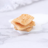 Stacked wax cereal squares with melted milk effect from Southlake Gifts Cinnamon Toast Crunch Candle — a realistic food-inspired décor piece that makes a unique and charming gift.
