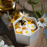 Daisy Beehive Candle Bowl lit with twin flames, showing intricate floral and bee details in honey-colored wax — a cozy handmade candle ideal for home décor and gift giving.