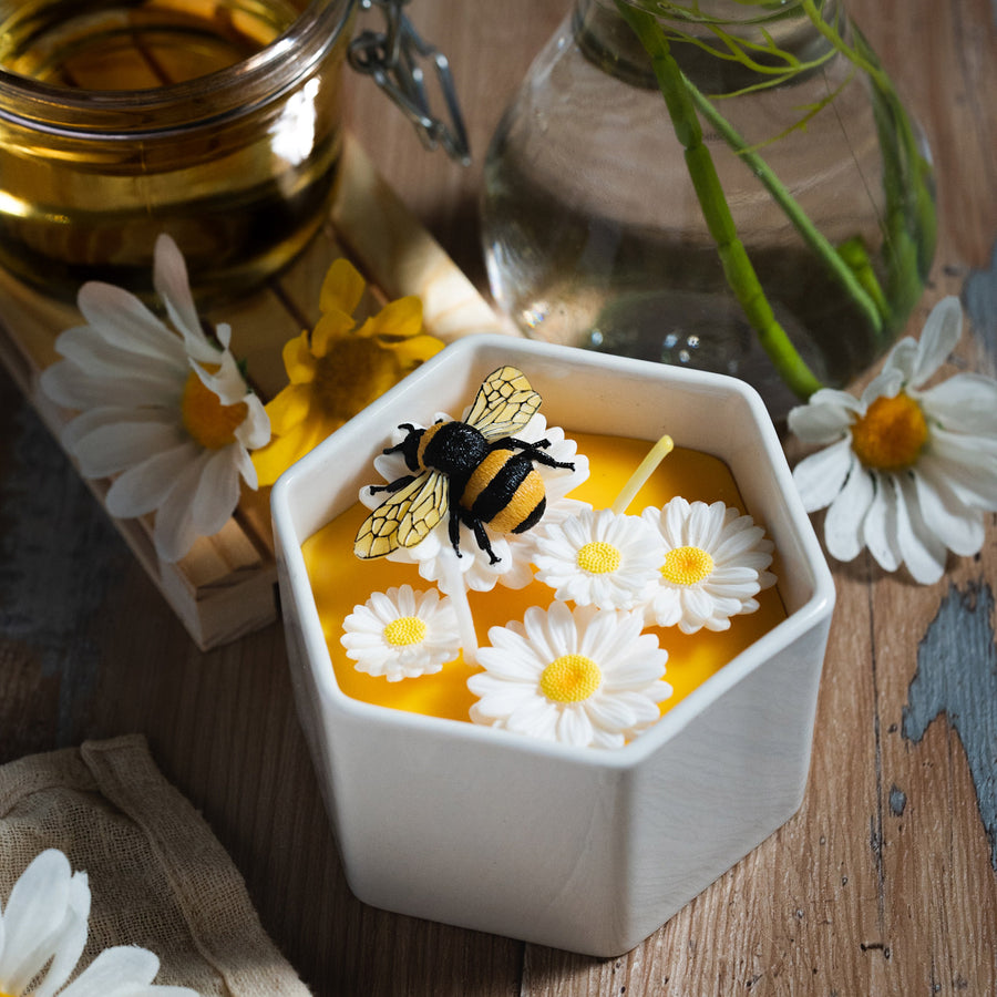 Daisy Beehive Candle Bowl lit with twin flames, showing intricate floral and bee details in honey-colored wax — a cozy handmade candle ideal for home décor and gift giving.