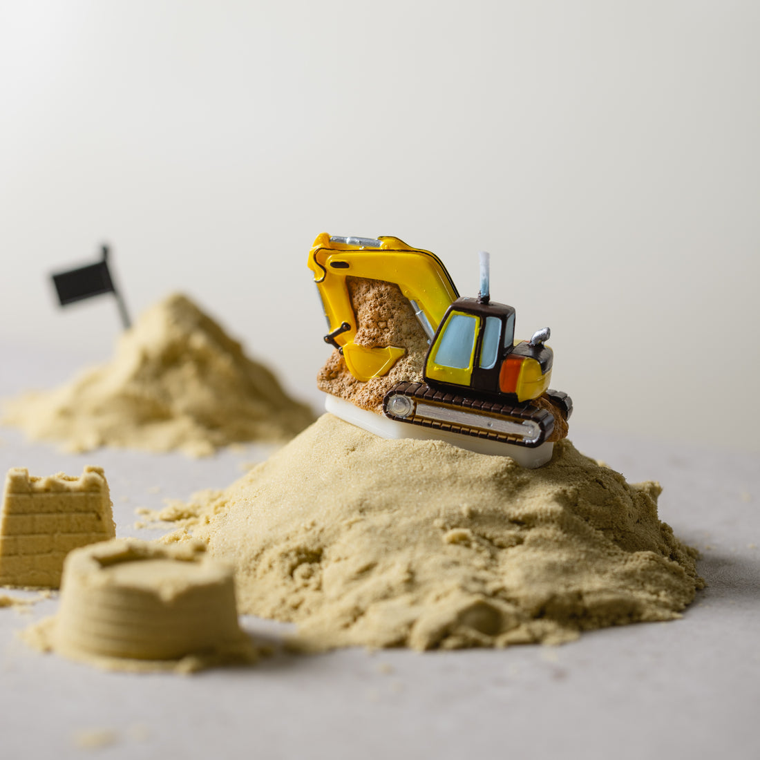 Southlake Gifts Excavator Candle styled in a miniature construction scene with sand and props, a handcrafted soy candle that works as a fun cake topper and novelty décor gift.