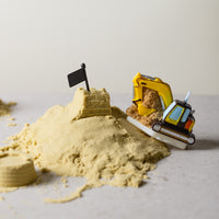 Southlake Gifts Excavator Candle shown in a construction-inspired setup with sand mounds, a handmade novelty candle ideal as a cake topper or imaginative gift for kids’ celebrations.