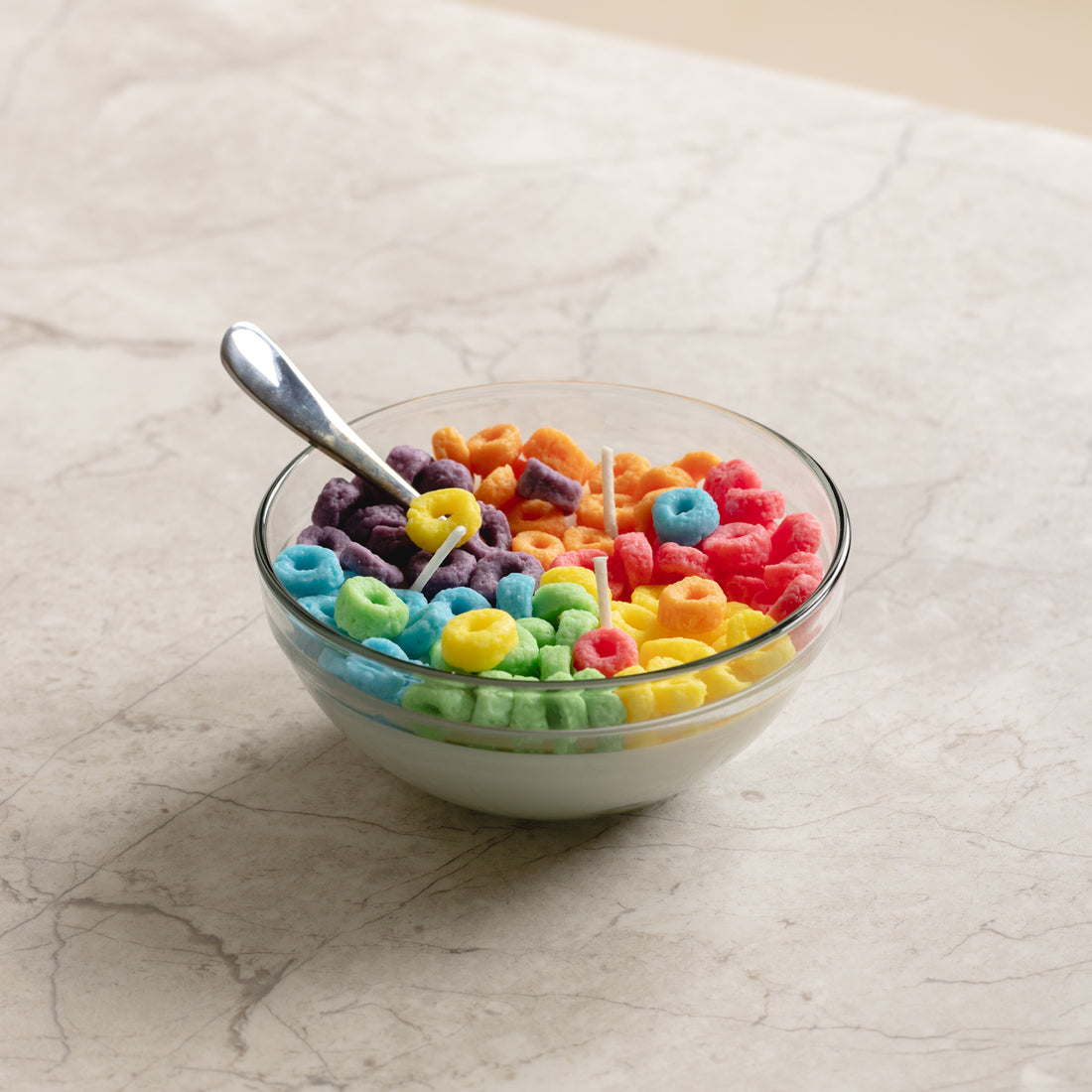 Southlake Gifts Fruit Loops Cereal Candle lit on a marble table — a whimsical hand-poured candle that looks like a real cereal bowl, ideal for gifting and brightening up modern homes.