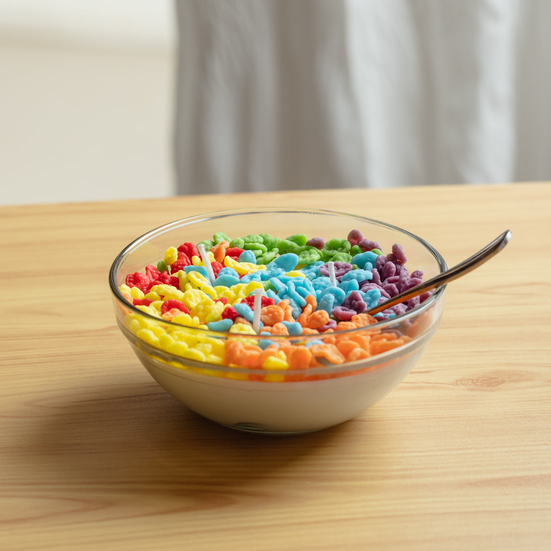 Fruity Pebbles Cereal Candle placed on a clean wooden tabletop — a handcrafted soy wax candle designed as realistic breakfast décor, ideal for gifting to candle and home décor fans.