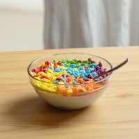 Fruity Pebbles Cereal Candle placed on a clean wooden tabletop — a handcrafted soy wax candle designed as realistic breakfast décor, ideal for gifting to candle and home décor fans.