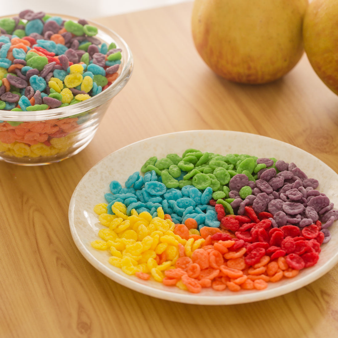 Fruity Pebbles Candle and a plate of colorful wax cereal pieces shown side by side — a detailed artisan handmade candle that captures realistic texture and makes a joyful novelty décor gift.