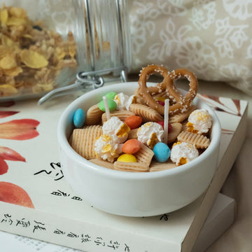 Southlake Gifts Snacks Bowl Candle on cozy tabletop, filled with realistic wax pretzels, popcorn, and candy pieces — a handmade food candle that makes a playful gift for décor lovers.