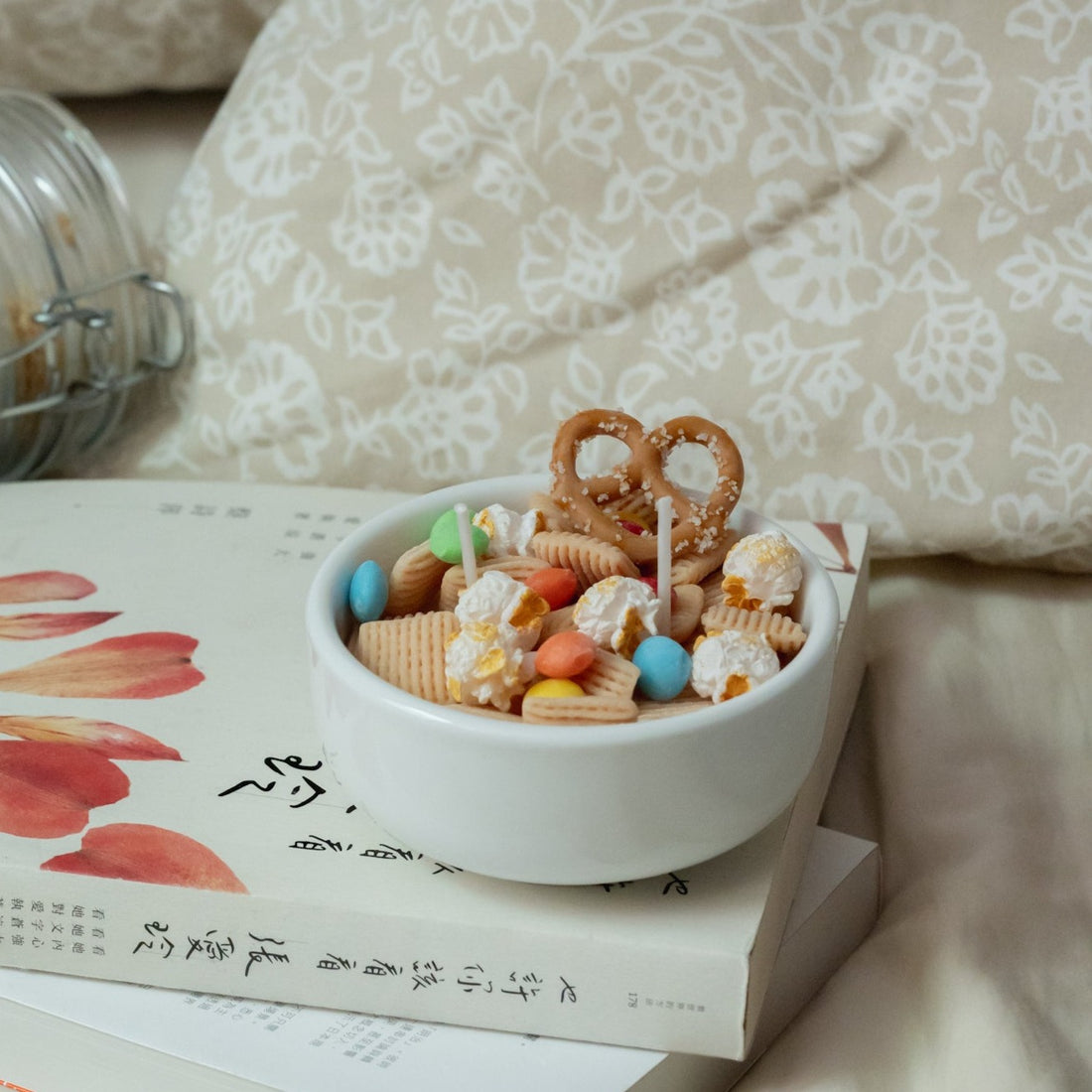 Playful snack-inspired candle on a white book background with colorful wax details — a novelty food candle that makes a thoughtful and conversation-starting gift.